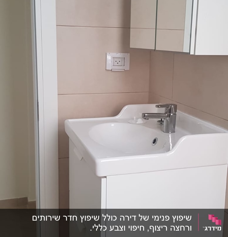 כיור לבן עם ארון ומראה בחדר אמבטיה